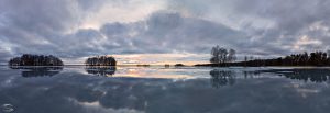 Panorama of a frozen lake with a cloudy sky during the blue hour
