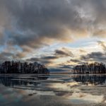 Panorama of a frozen lake with a cloudy sky during the blue hour
