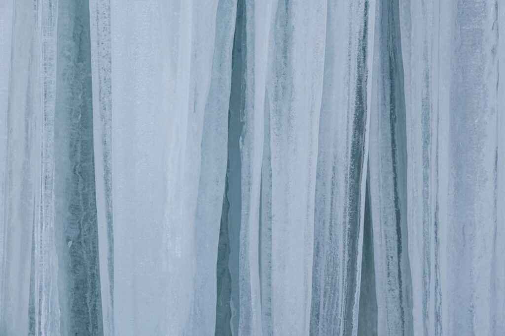 Eiszapfen in verschiedenen Blautönen, die eine frostige Textur und klare Linien zeigen.