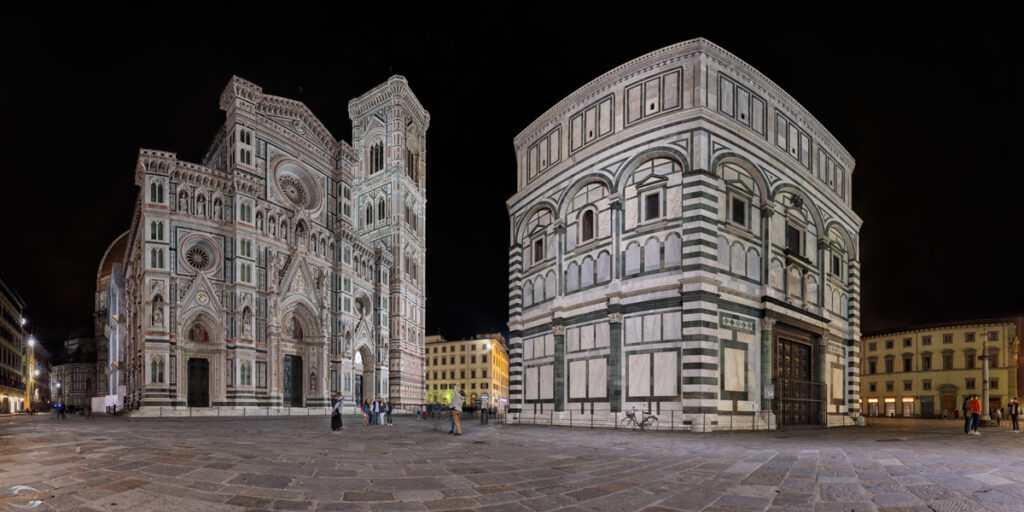 Nachtaufnahme der Piazza dei Miracoli in Pisa: Kathedrale von Pisa und Baptisterium aus weiß-grünem Marmor, beleuchtet.