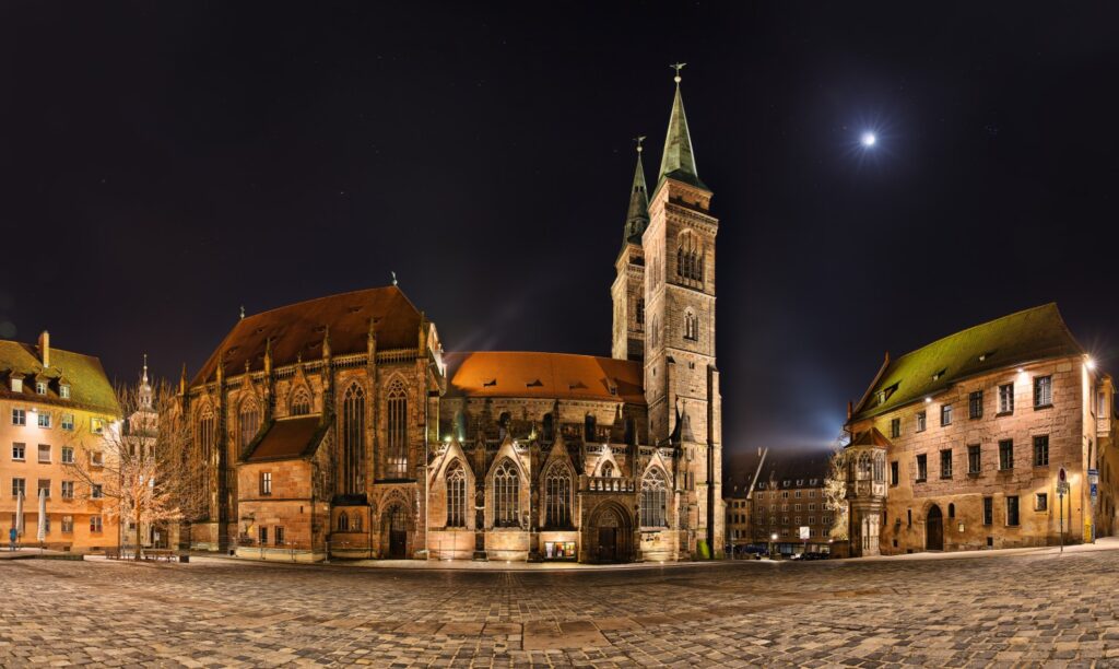 Nürnberger Kirche bei Nacht mit beeindruckender Architektur und sternklarem Himmel im Hintergrund.