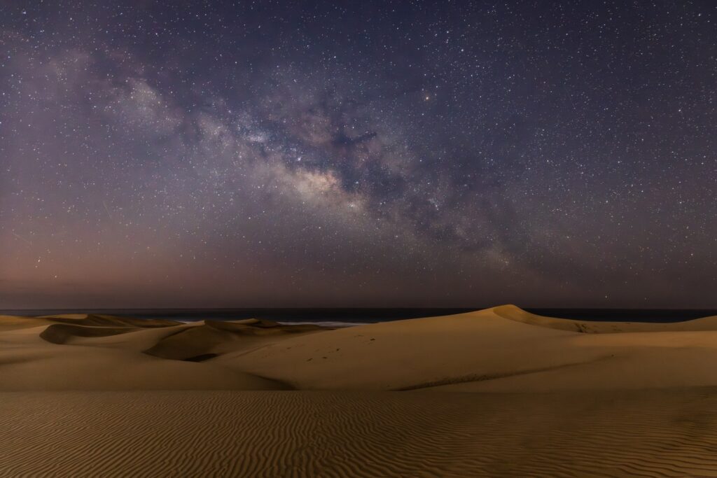 Milchstraße über goldenen Sanddünen in der Wüste bei Nacht – Sternenhimmel und ruhige Dünenlandschaft